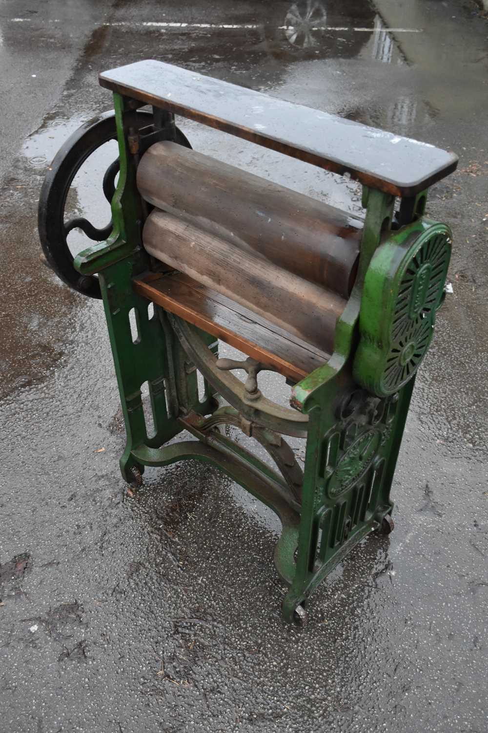 TAYWIL; a cast iron and wooden green painted mangle, height 122cm, together with a cast iron and