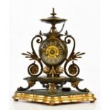 An aesthetic movement French bronze and gilt metal mantel clock with circular finial above the