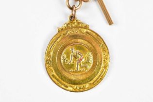 A 9ct yellow gold bowling medal, given by Dr G J Awburn 1950, suspended on a 9ct Albert chain with T