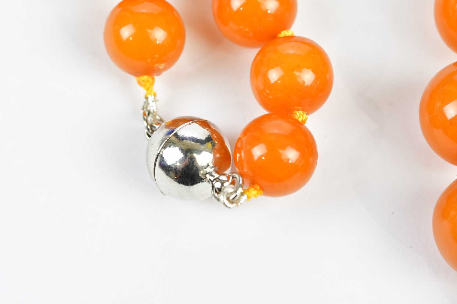 A cherry amber coloured beaded necklace, with silvered bead clasp, approximate weight 67g. - Image 2 of 4