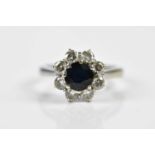 An 18ct white gold sapphire and diamond flowerhead ring, size J, approx. 4.2g. Condition Report: The