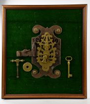 An Eastern cast metal door lock with pierced open decoration with key, framed, overall 55 x 48cm.