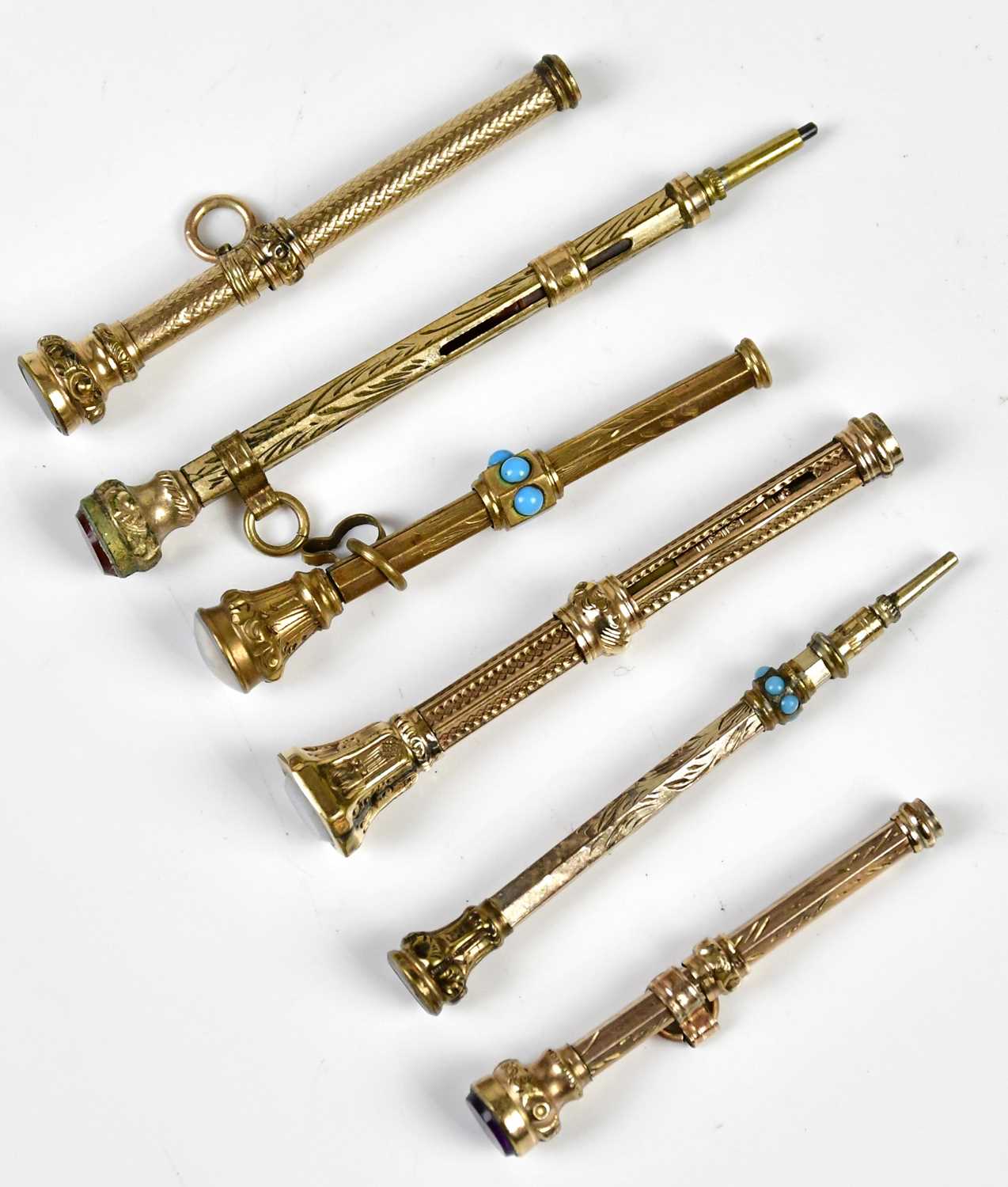Six late Victorian yellow metal propelling pencils, with chased/engine turned decoration, and