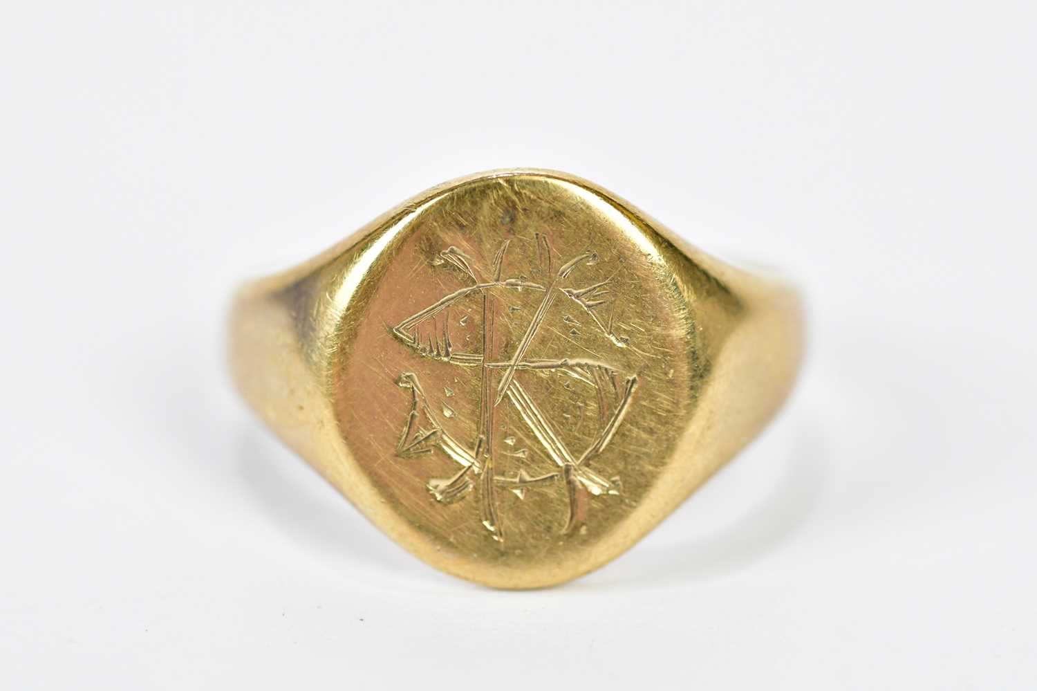 A 9ct yellow gold signet ring with engraved initials to the oval platform, size Q, approx. 4.85g.