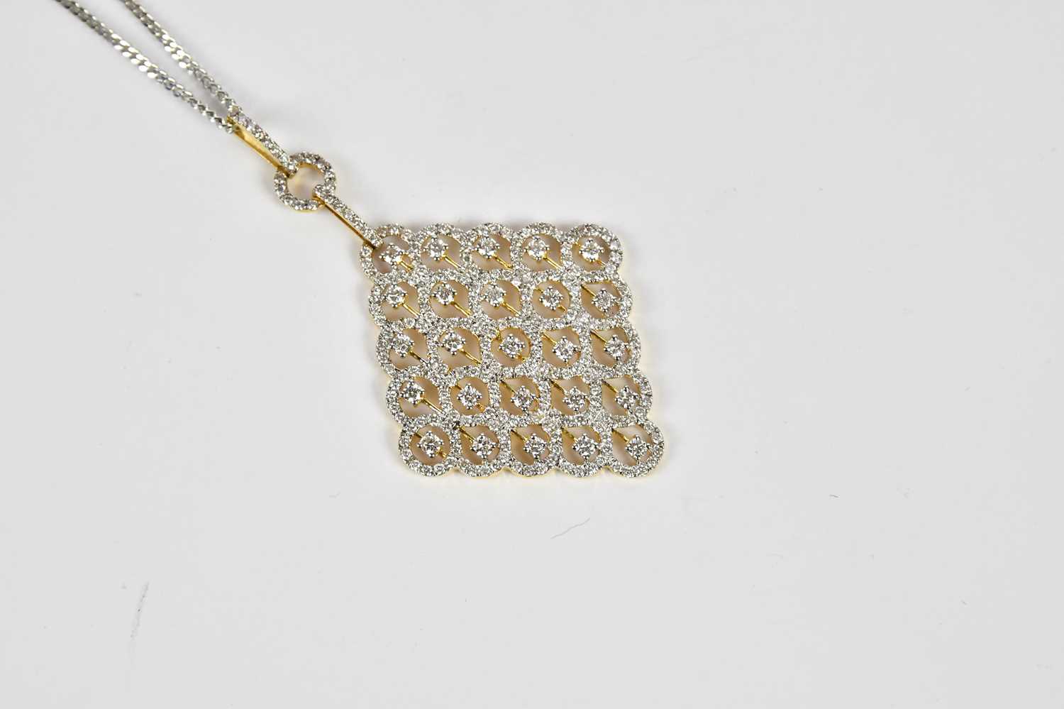 An 18ct yellow and white gold pierced diamond set lozenge shaped pendant, suspended on a 9ct white - Image 2 of 4