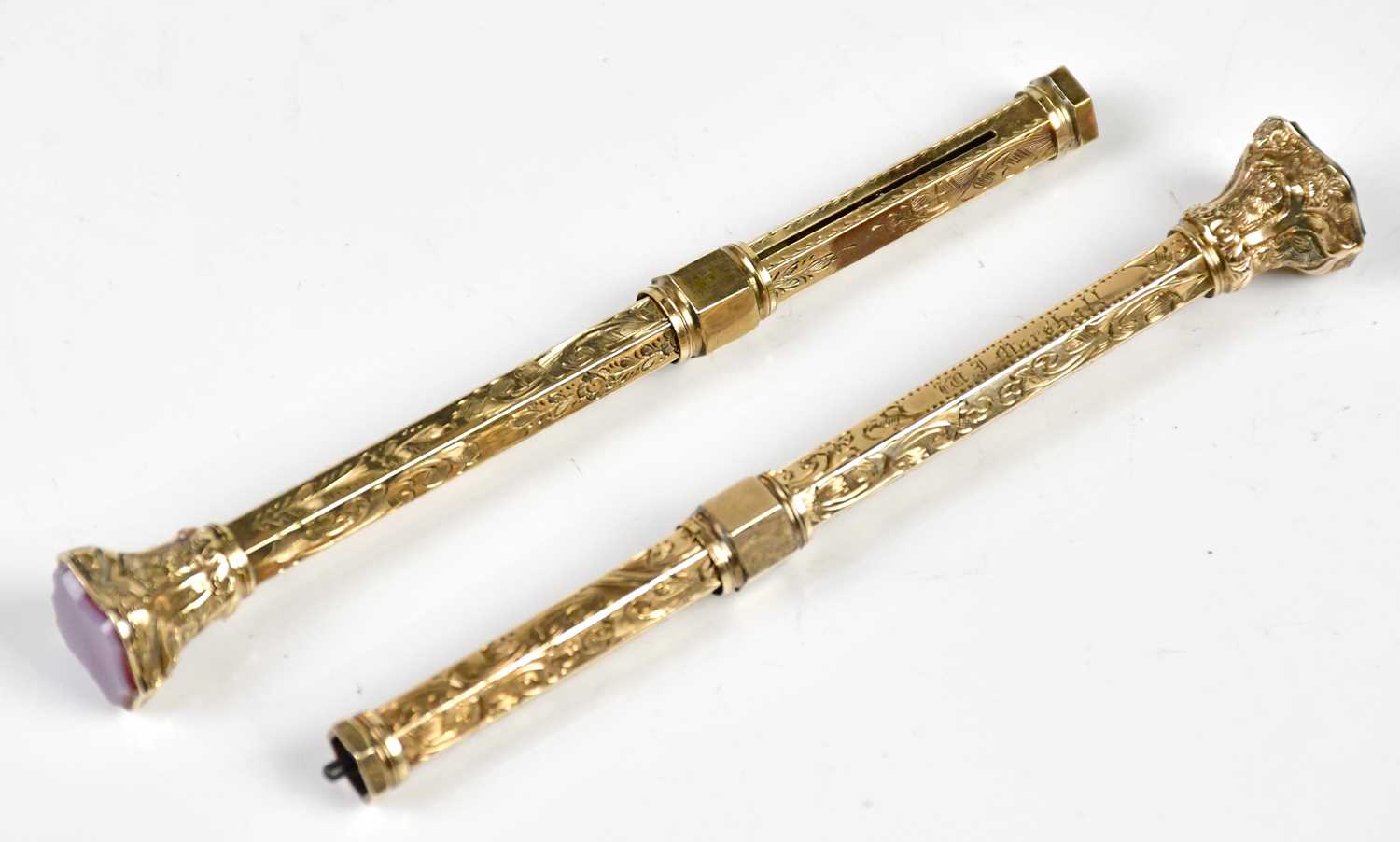 Two Victorian yellow metal propelling pencils, including an example with green shield shaped