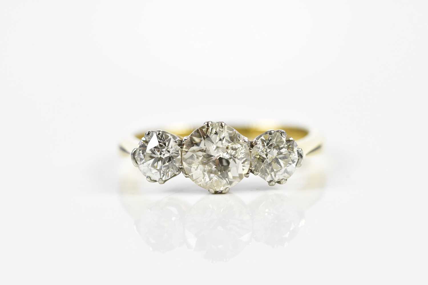 An 18ct yellow gold three stone diamond ring, the central old cut stone weighing approx. 1.20cts,