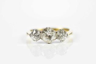 An 18ct yellow gold three stone diamond ring, the central old cut stone weighing approx. 1.20cts,