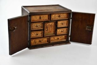 A 19th century oak and marquetry table cabinet, with two doors enclosing eight drawers around a