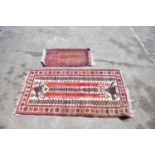 An Eastern rug decorated with stylised motifs and symbols on a red and cream ground, 208 x 110cm,