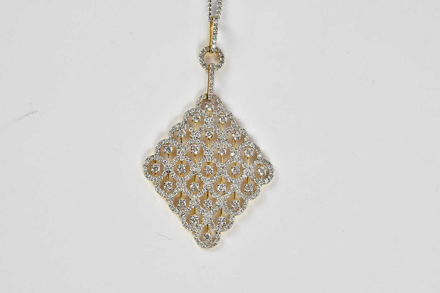 An 18ct yellow and white gold pierced diamond set lozenge shaped pendant, suspended on a 9ct white - Image 3 of 4