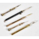 Four late 19th/early 20th century yellow metal tooth picks, including an example with cast linear