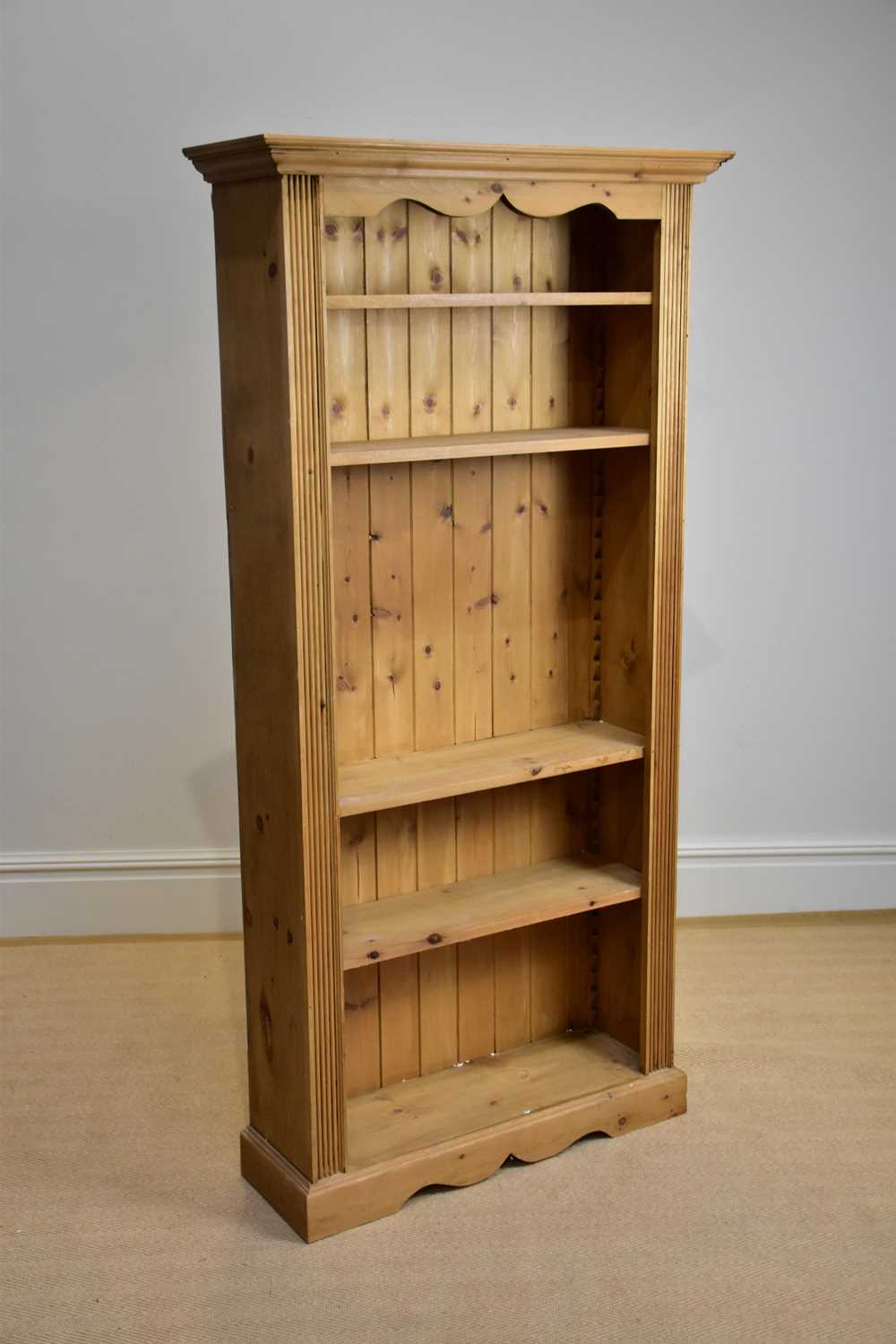 A modern pine bookcase with moulded cornice above an arrangement of four shelves, height 180cm,