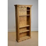 A modern pine bookcase with moulded cornice above an arrangement of four shelves, height 180cm,