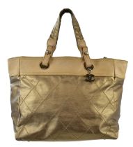 CHANEL; a Paris-Biarritz coated quilted canvas and leather gold large tote bag, trimmed with beige