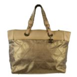 CHANEL; a Paris-Biarritz coated quilted canvas and leather gold large tote bag, trimmed with beige