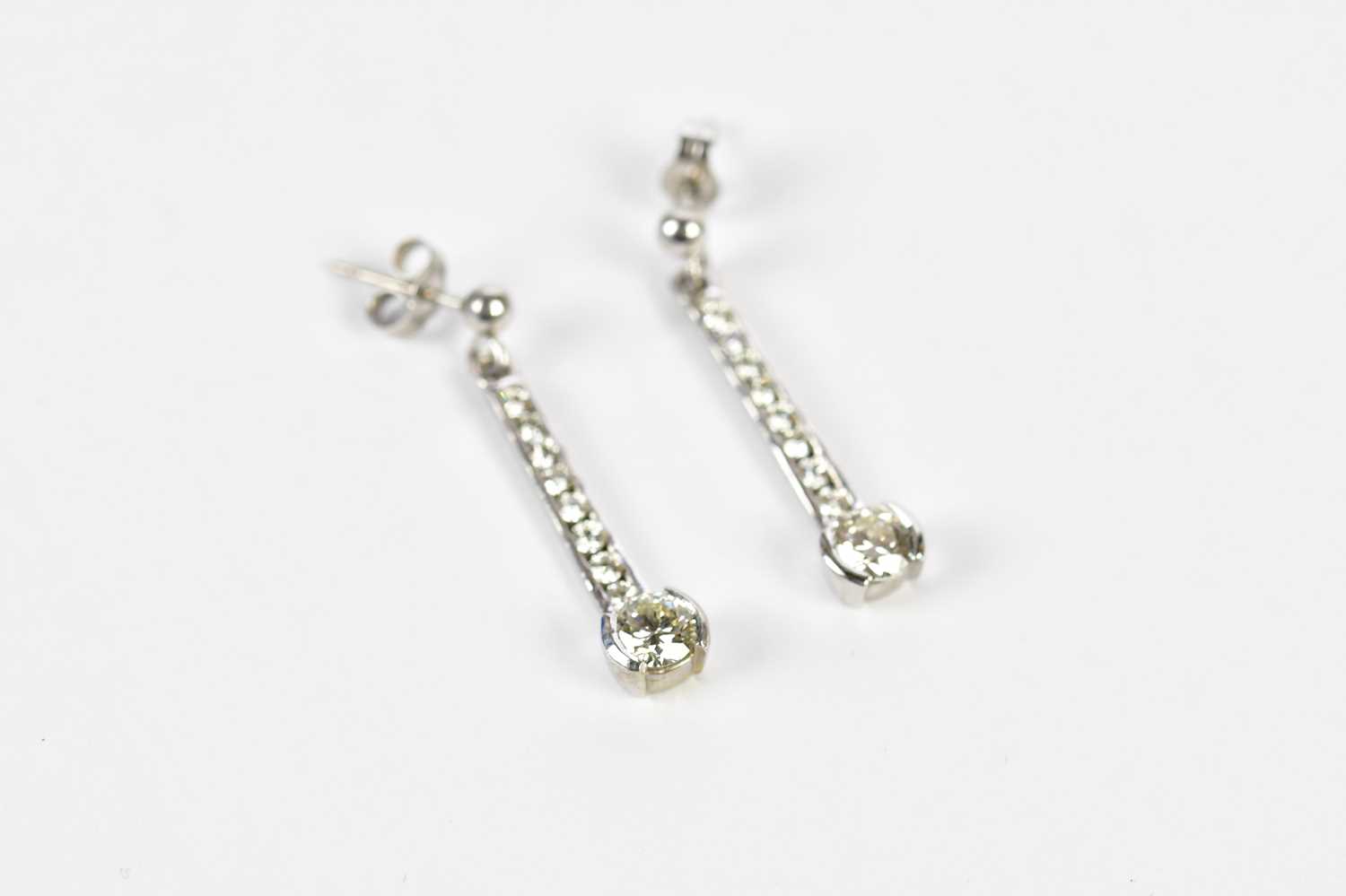 A pair of 18ct white gold diamond drop earrings, the channels set with eight tapering round - Image 2 of 4