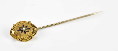 A yellow metal pin, set with a central pearl.