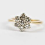 An 18ct yellow gold seven stone diamond set flower head ring, each round brilliant cut stone