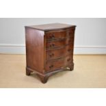 A reproduction mahogany serpentine fronted chest of four drawers on bracket feet, height 75cm, width