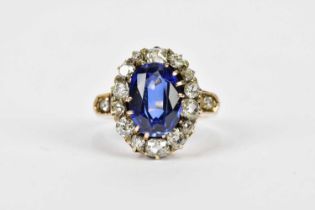 A yellow metal antique sapphire and diamond oval cluster ring with central oval sapphire within a