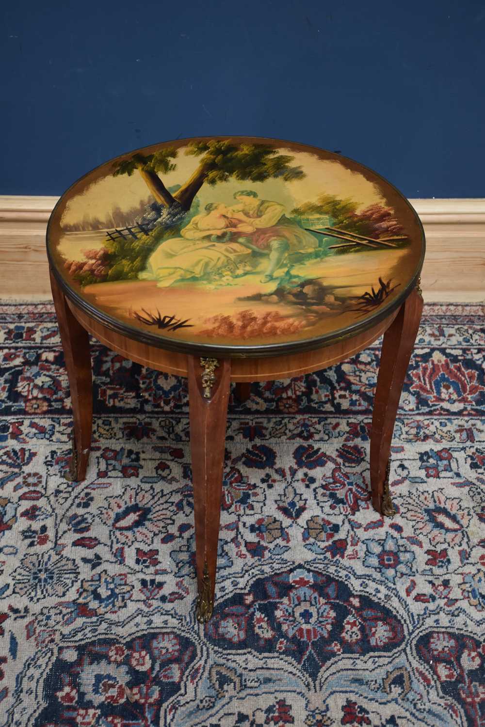 A reproduction French style coffee table of circular form, with transfer printed decoration to the