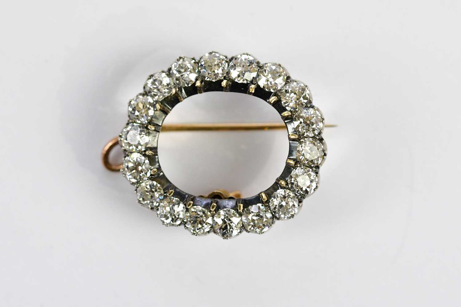 An Edwardian yellow metal diamond set combination brooch/pendant, the border formed of eighteen