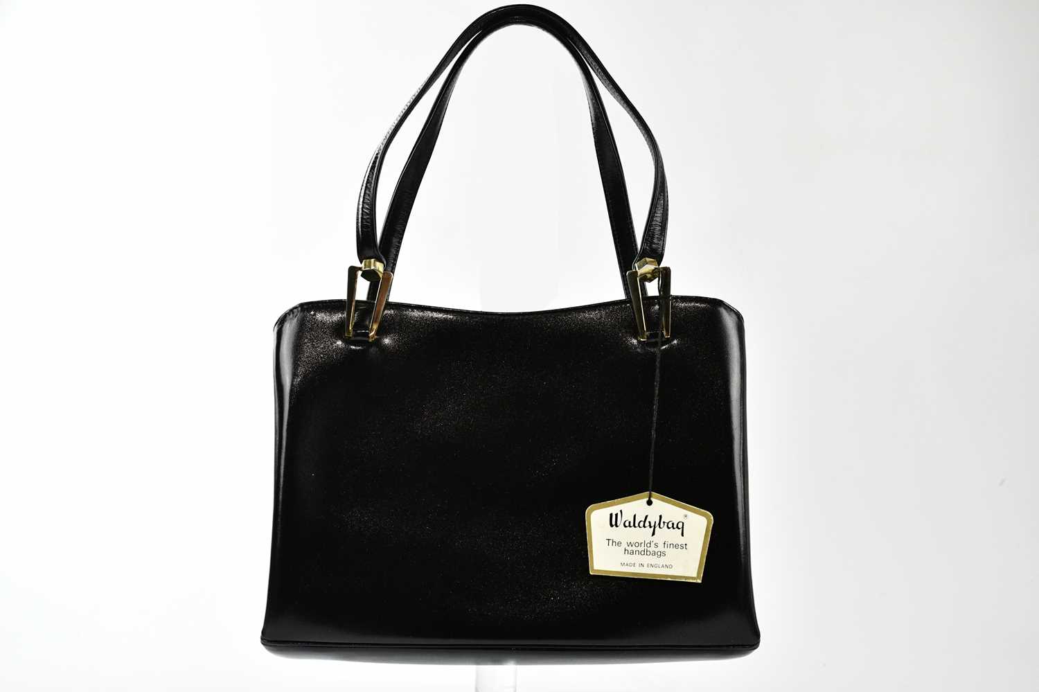WALDYBAG; a 1950s unused and boxed black leather handbag with gold tone hardware, beige suede