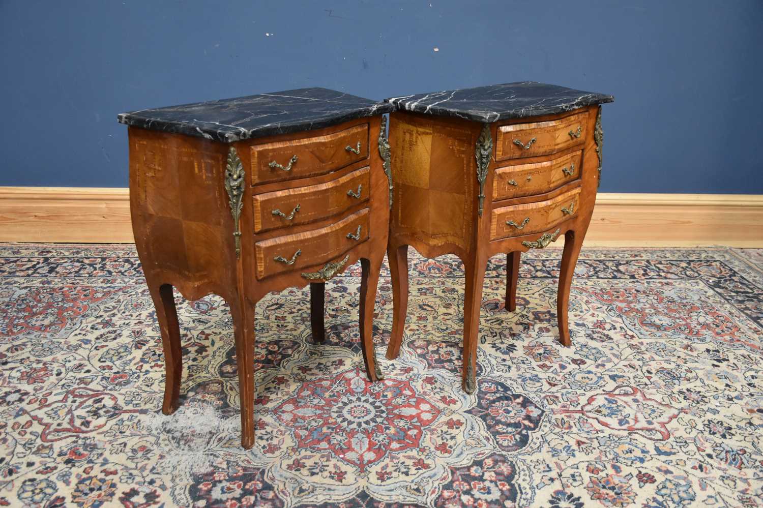 A pair of reproduction serpentine front marble top bombe shaped three drawer side cabinets with