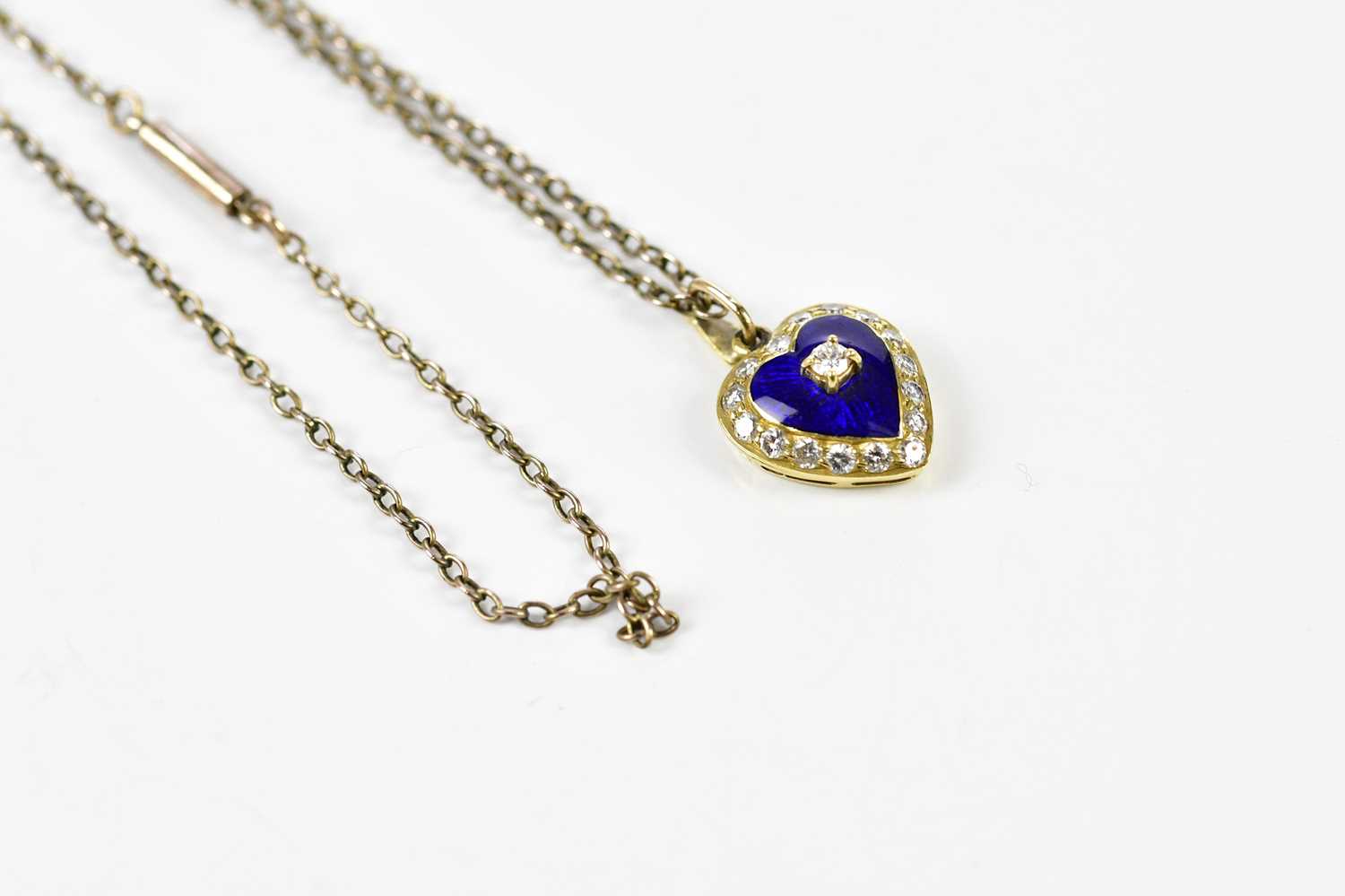 An 18ct yellow gold heart shaped pendant centred with a round brilliant cut diamond on a blue - Image 2 of 5