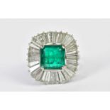 A white metal emerald and diamond ballerina cluster ring centred with a square cut emerald within