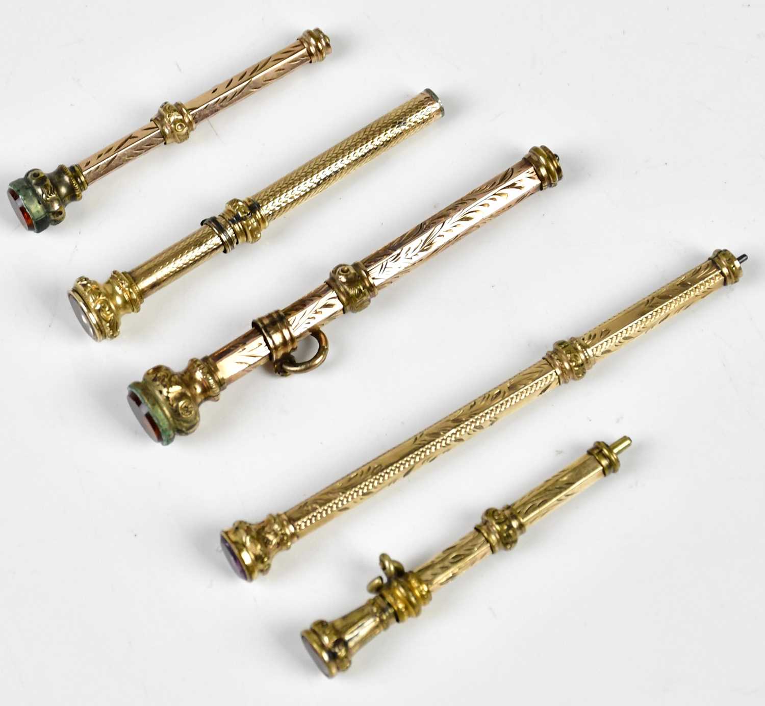 Five Victorian yellow metal propelling pencils, including an example with engine turned