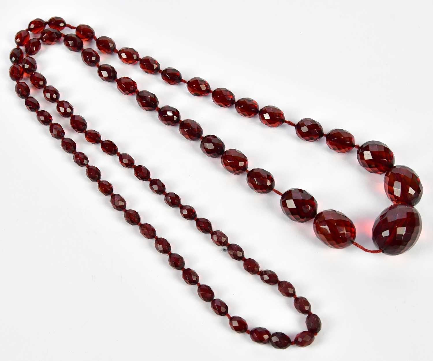 A cherry amber facet cut graduated bead necklace, length 88cm, approx 58.6g.