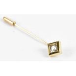 A yellow metal stick pin with collet set round brilliant cut diamond weighing approx. 0.60cts,