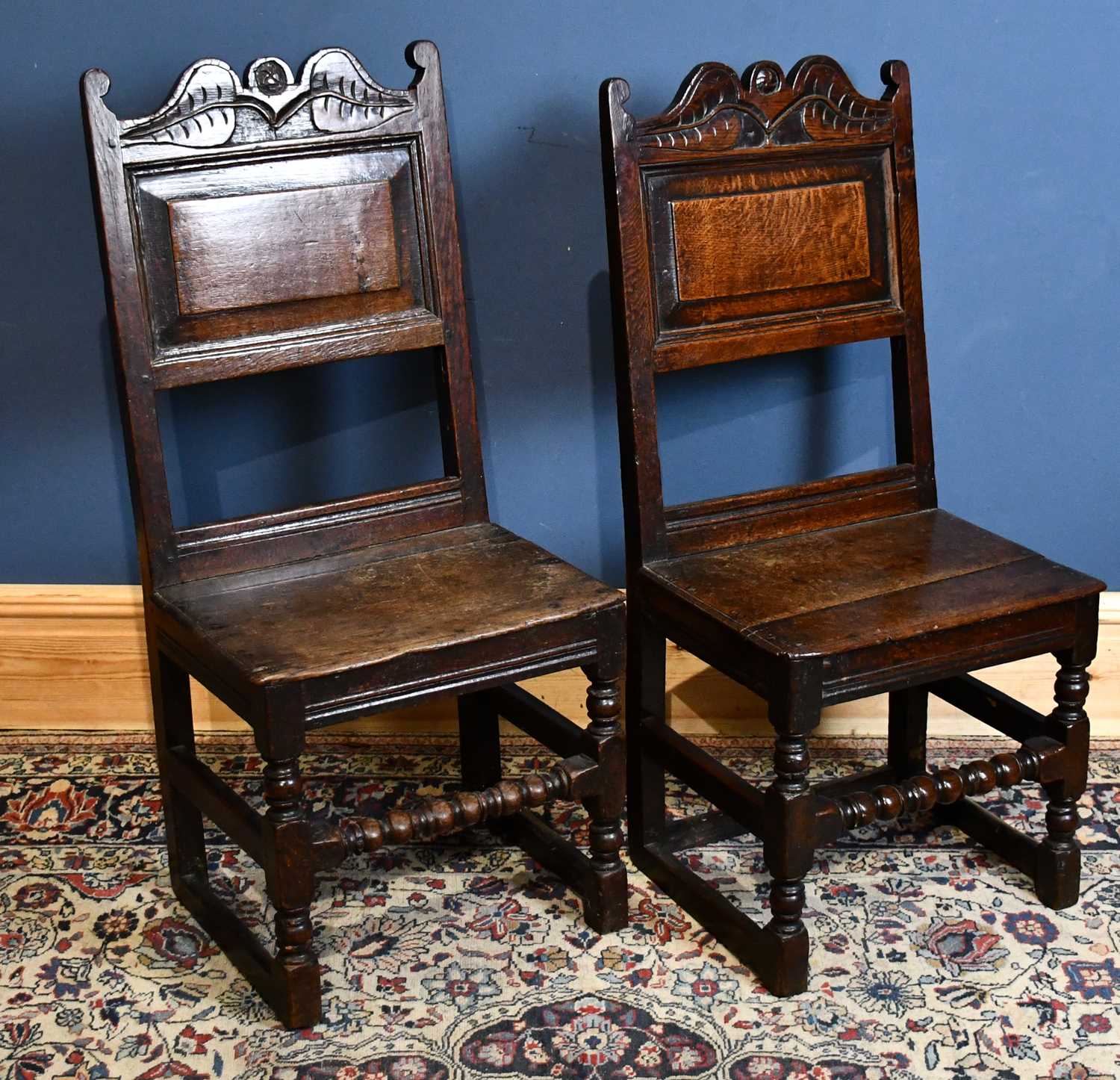 A pair of oak back stools, circa 1700, with panelled backs and plank seats, on turned and block