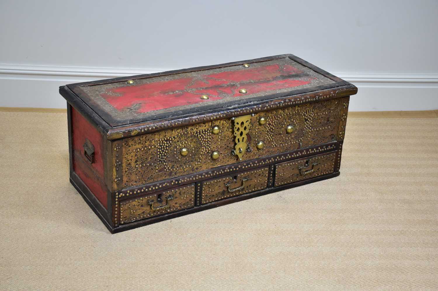 An early 20th century Zanzibar chest with applied studded decoration and hinged top above three