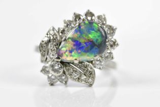 A white metal black opal and diamond cluster ring, the opal approx. 13 x 8mm, in claw setting with