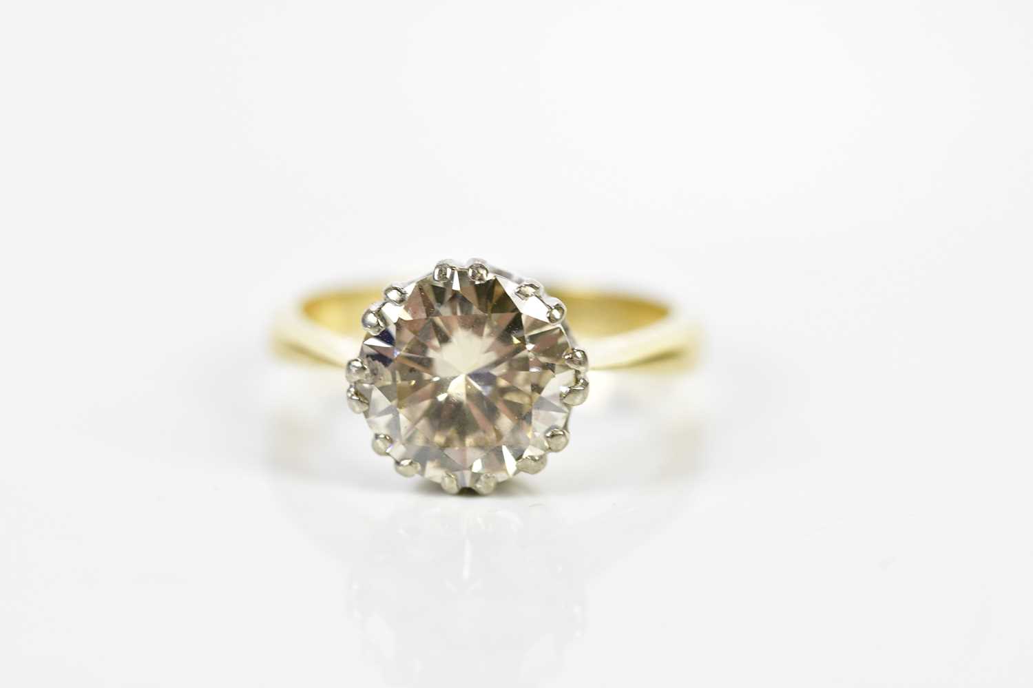 A yellow metal diamond solitaire ring, the round brilliant cut claw set stone weighing approx. 2.