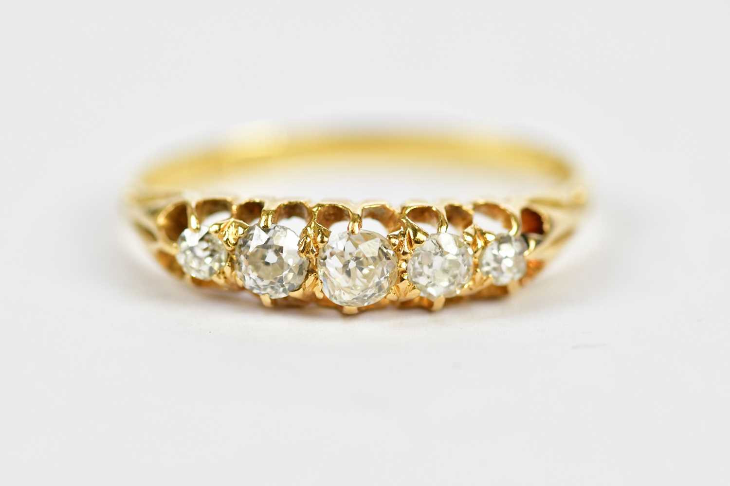 An 18ct yellow gold graduated five stone diamond ring, the claw set old cut stones set with