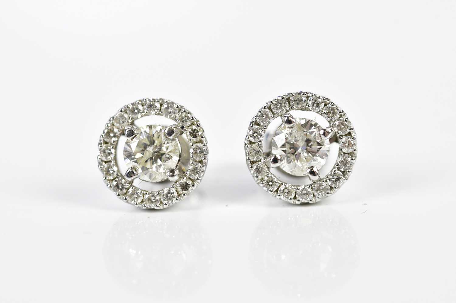 A pair of 18ct white gold and diamond halo set ear studs, each with central round brilliant cut