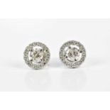 A pair of 18ct white gold and diamond halo set ear studs, each with central round brilliant cut