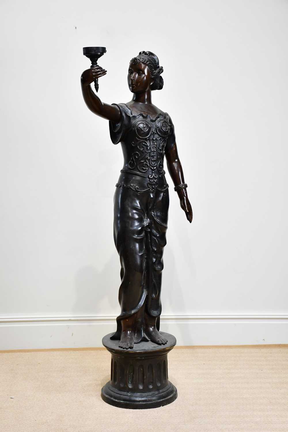 A large bronze lamp modelled as a maiden supporting a lantern, on fluted plinth base, height 179cm.