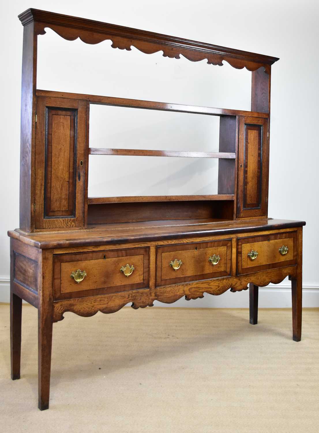 An 18th century oak and mahogany crossbanded dresser with open plate rack back, with three fixed