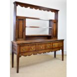 An 18th century oak and mahogany crossbanded dresser with open plate rack back, with three fixed