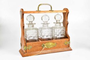 An early 19th century oak cased three bottle tantalus, height 33cm.