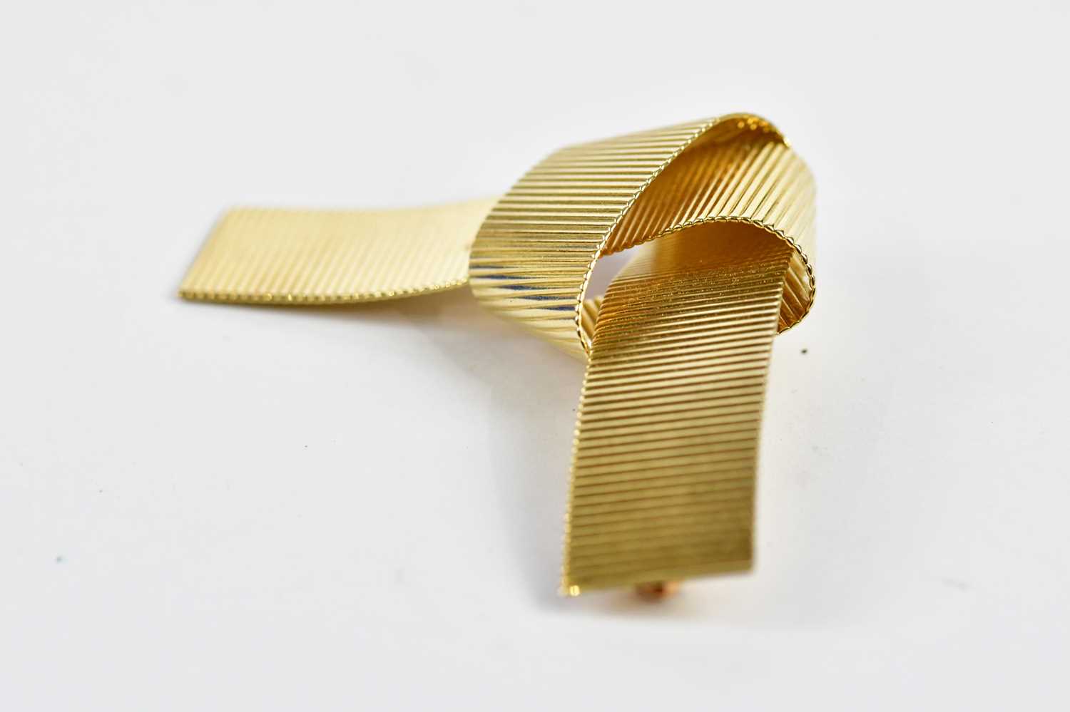 A 14ct yellow gold textured tied knot brooch of abstract form, length approx 62mm, approx 10.63g. - Image 2 of 3