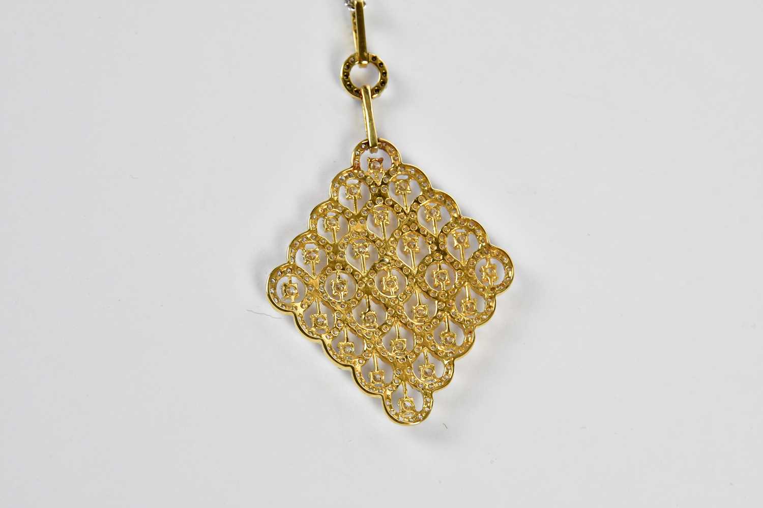 An 18ct yellow and white gold pierced diamond set lozenge shaped pendant, suspended on a 9ct white - Image 4 of 4