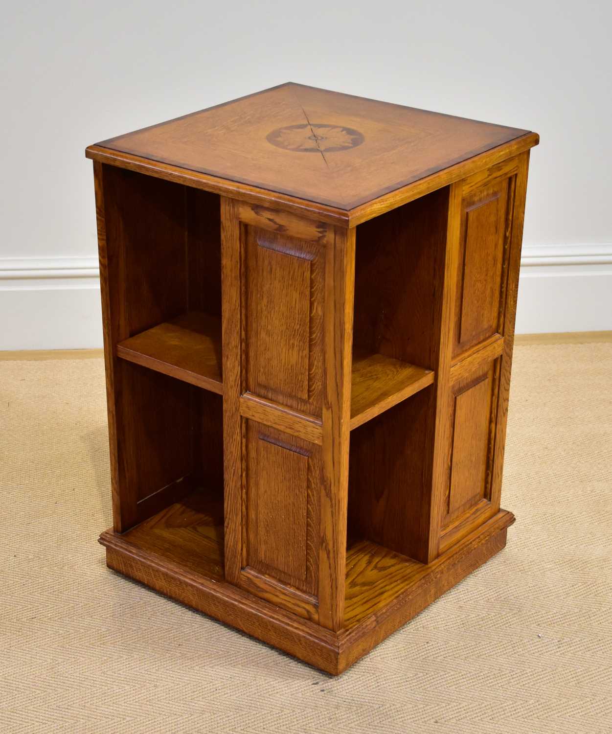 A reproduction inlaid oak revolving bookcase, height 76cm, depth 48cm.