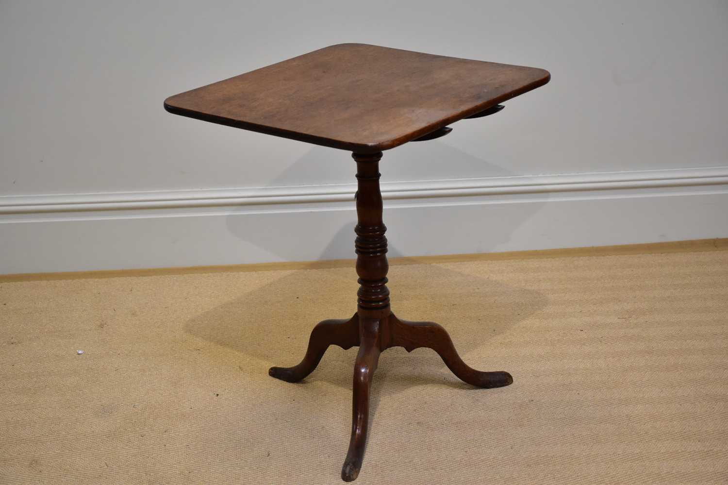 An early 19th century oak tilt-top occasional table, with rectangular top, on turned column and