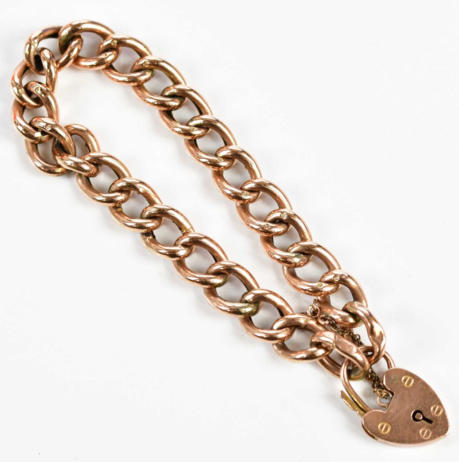 A 9ct rose gold hollow curb link bracelet with padlock and safety chain, approx. 15.85g.